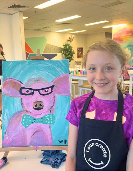 kids classes - child with her painting of a pink pig and blue spotty bow tie